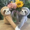 Fresh flowers in vase with sloth plush 