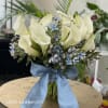 A lush profusion of white callas and blue tweedia. Classic and elegant.