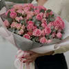 The bouquet includes bright pink roses of different shades and sizes, and