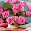 The bouquet includes bright pink roses of different shades and sizes, and
