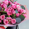 The bouquet includes bright pink roses of different shades and sizes, and