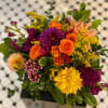 Colors of Orange, Purple, Yellow and Gold grace this beautiful arrangement.
This gorgeous