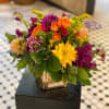 Colors of Orange, Purple, Yellow and Gold grace this beautiful arrangement.
This gorgeous