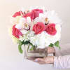 A modern compact arrangement of hot pink roses, hydrangeas, cymbidium orchids accented