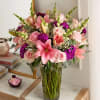 All-around arrangement of pink roses and Asiatic lilies, purple dianthuses and limoniums