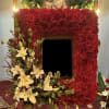 This lovely frame comprises red Roses, white Lilies, and green Bells. In