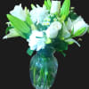 This arrangement includes white roses, white asiatic lilies, white and white carnations.
