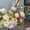 An airy, elegant arrangement of blush-toned roses, ranunculus, hydrangeas, and lisianthus, accented