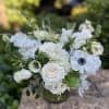 Crisp whites flowers featuring panda anemones, tulips, roses, and succulents, accented with