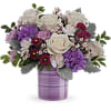A bouquet of pink &amp; purple blossoms styled in a purple cylinder