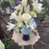 This peaceful arrangement includes roses, oriental lilies, fuji mums, blue delphinium, blue
