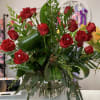 24 red roses arranged in a variety of greenery with faux diamond