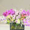 Luxurious black-framed clear vase adorned with purple, lavender, and pink blooms. 

To