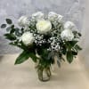 Dozen white roses arranged traditionally in a glass vase. A classic and