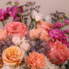 A mixture of peach, pink, orange, ivory and white with foliage accent