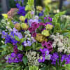 Bright green and purple florals make up this vibrant arrangement. Bells of