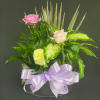 A decorative container is filled with assorted green plants, fresh cut flowers