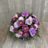 Assorted purple flowers in a cube. Colors and flowers may vary.
