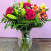 This stunning floral arrangement features red roses, lilies, alstroemeria and more