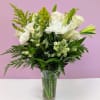 This arrangement feature white roses, lilies, mums and more.