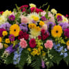 A stunning casket spray bursting with color and life&mdash;featuring vibrant roses, gerbera