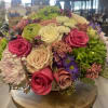 Seasonal flowers designed in vase with greenery and filler. 