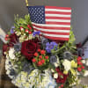 Red, white and blue flowers with an American Flag.  Celebrate our