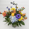 Neptune is a whimsical arrangement with blue, yellow and orange flowers that