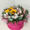 A composition of orchids and sunflowers in a box creates a vibrant