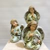 Three varieties of angels: One holding a bird, one praying, and one