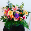 A lush, colorful design of stargazer lilies, gerbera daisies, lisianthus, delphinium, snapdragon