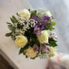 Arrangement with white roses and carnations; lavender alstroemerias and stock; accented with