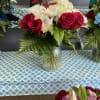 Red roses with daisies in a mini vase
