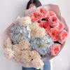 A cheerful blend of coral garden roses, soft cream carnations, and powder