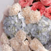 A cheerful blend of coral garden roses, soft cream carnations, and powder