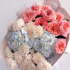 A cheerful blend of coral garden roses, soft cream carnations, and powder