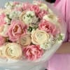 An irresistibly soft and charming bouquet of cream ranunculus, pink tulips, and