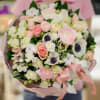This delicate arrangement is a dreamscape of soft pinks and crisp whites