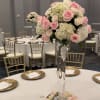 A round centerpiece of white hydrangea, pink and cream roses placed on