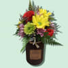 A cute, petite floral arrangement on top of a 12 oz. Harvest