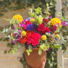 Terra cotta vase filled with a mixture of Roses, carnation, fillers, in
