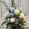 White Roses, blue carnations, blue delphinium in a vase