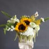 A more modern design in a boat shaped vase with farm flowers