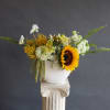 A more modern design in a boat shaped vase with farm flowers