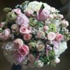 Grand arrangement with assorted pink roses, white hydrangea, and pale green accents.