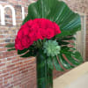 A leaning bouquet of 50 premium, long stemmed red roses create a