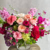 A premium full Arrangement with reds, purples, peaches and pinks in a