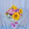Beautiful bouquet featuring sunflowers and pink roses with green accents, wrapped in