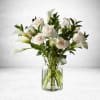 A stunning arrangement of delicate white roses and calla lilies, elegantly displayed
