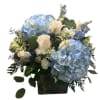 Large mound style arrangement in cube featuring blue hydrangeas, roses, eucalyptus, and